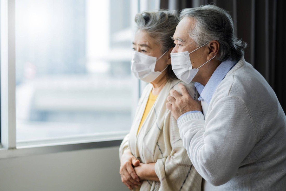 asian-retired-elderly-couple-wearing-face-masks-watch-world-through-their-home-window-hand-hug-lonely-sadness-expressionasian-people-home-isolation-social-distancing-stay-home-ideas-concept